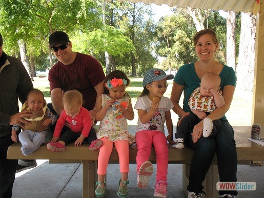 kids and their parents are sitting on a bench